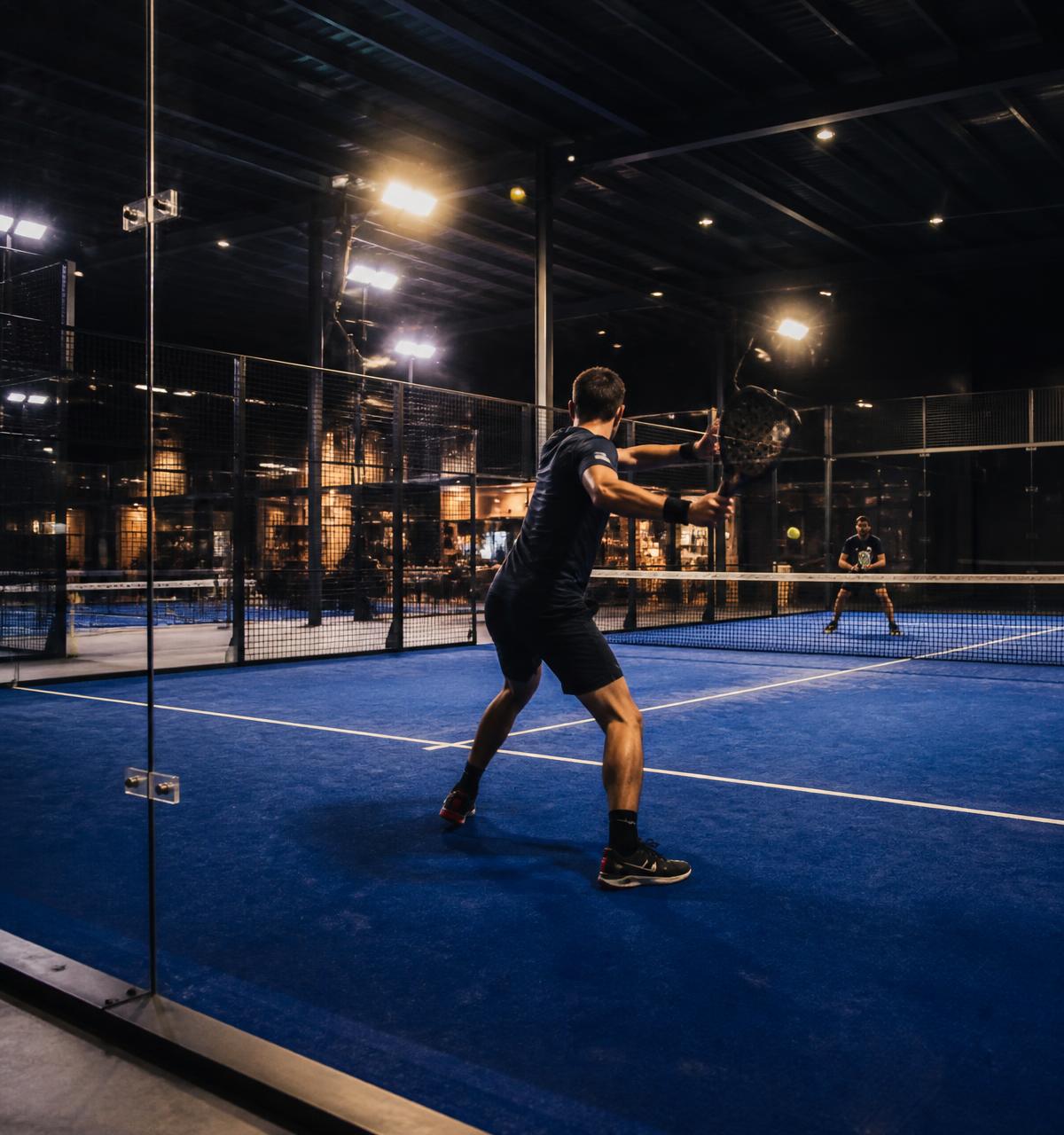 Rally op een overdekte padelbaan in de avond